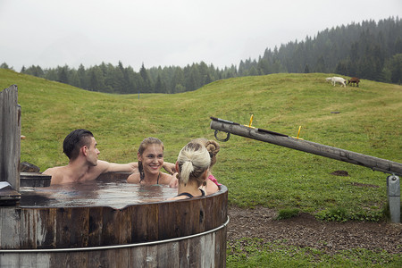 四个成年朋友在奥地利蒂罗尔的的乡村热水浴缸里放松
