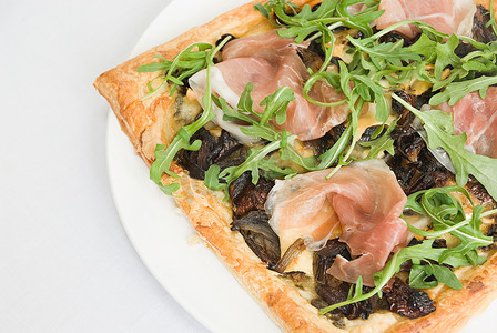 餐盘美食美食摄影照片_菲罗糕点披萨上面有熏火腿焦糖洋葱和火箭