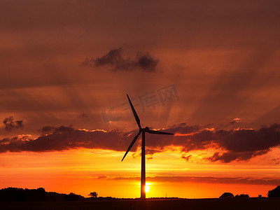 夕阳西下的天空中的风力涡轮机