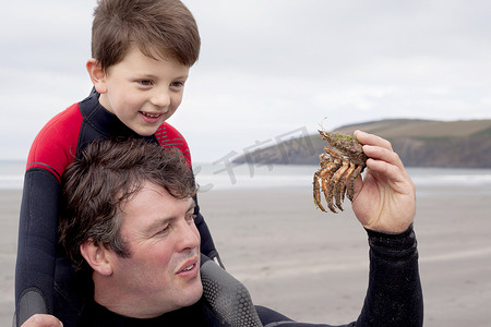 苹果游戏摄影照片_父亲抱着儿子抓着螃蟹