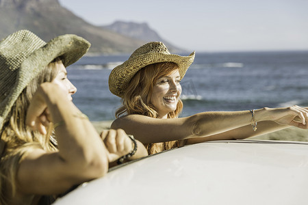 共享车摄影照片_南非开普敦海岸两位中年女性朋友靠在车顶上