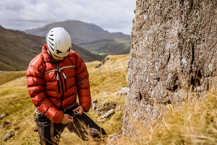 年轻的男性登山者系紧绳索英国坎布里亚郡湖区