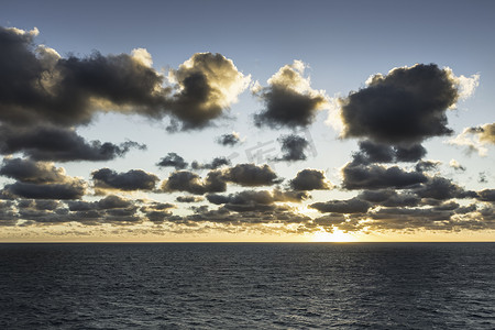 日出时蔚蓝的大海和艳阳下的云