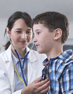 医生用听诊器检查男孩的呼吸