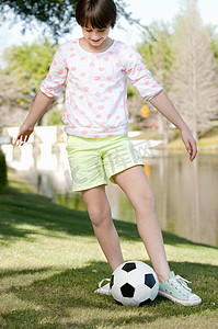 十岁女孩在公园里踢足球