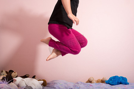 家居卧室背景摄影照片_在床上跳跃的孩子