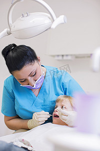 坐在牙医椅上的女孩正在做牙科检查