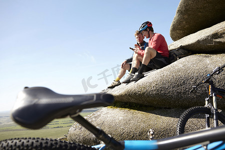 山水人摄影照片_骑自行车的人在露出地面的岩石上休息