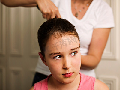 少女刷牙摄影照片_一个把女孩的头发往后扎的女人