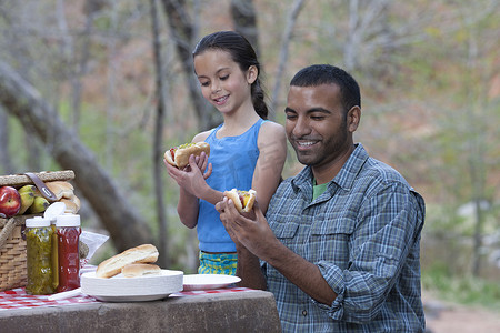 多子女摄影照片_美国亚利桑那州塞多纳市年轻男子和他的女儿在露营地吃汉堡