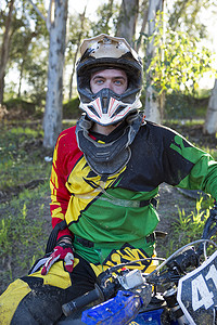 森林中的年轻男子越野摩托车手肖像