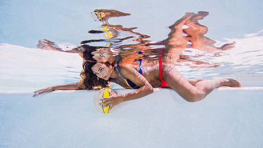 一名女子在游泳池水下穿着比基尼睁开眼睛