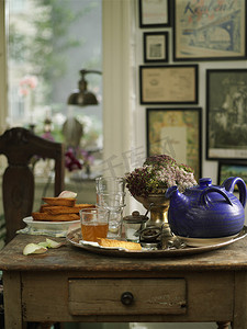 桌子上的复古托盘上有几杯茶和茶壶