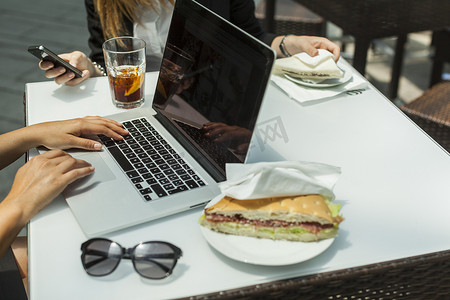 少数民族矢量傈僳摄影照片_商务女性在工作午餐时使用笔记本电脑