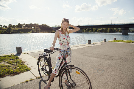 奥地利维也纳多瑙岛河边骑自行车的年轻女子肖像