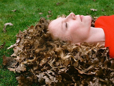 干树叶摄影照片_头发上有干树叶的女人的肖像