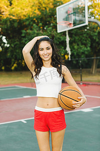 裁剪室摄影照片_一名年轻女子在球场上打篮球