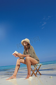 一名女子在海滩上阅读