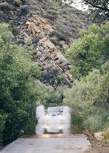 美国加利福尼亚州圣巴巴拉越野车在乡村公路上的深水中行驶