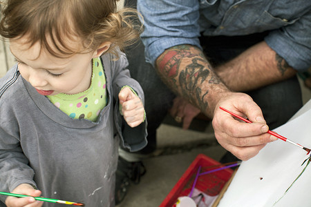 父亲和女儿在画架上作画