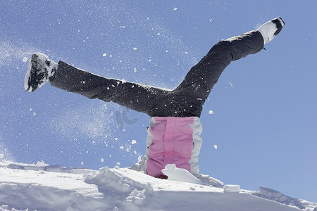 一名女子穿着滑雪靴在雪地里玩耍