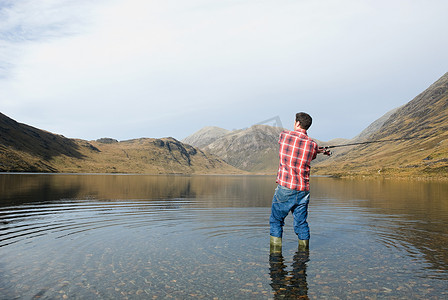 一名男子在湖里钓鱼