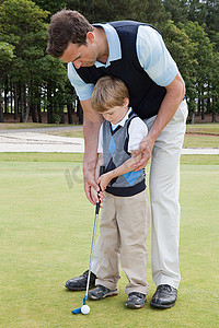 高尔夫7摄影照片_父亲教儿子打高尔夫球