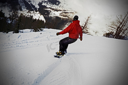 山水人摄影照片_男性骑滑雪板后视