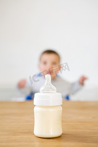 婴儿奶瓶在前景婴儿在背景