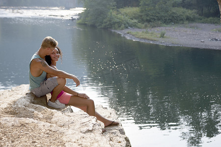 美国宾夕法尼亚州汉堡一对年轻夫妇坐在岩壁上