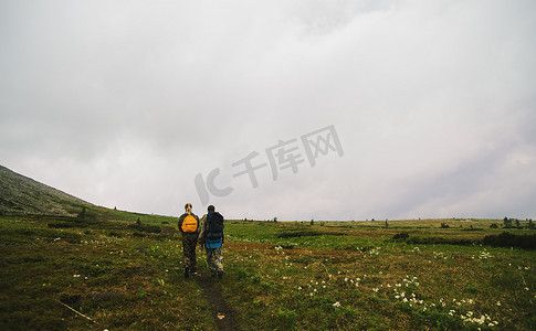 俄罗斯乌拉尔山脉山谷景观中徒步旅行的男人和女人的背影