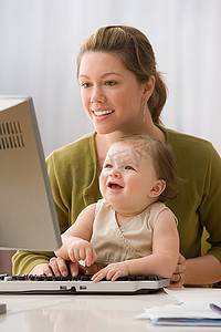 父母与孩子沟通摄影照片_使用电脑的母女俩