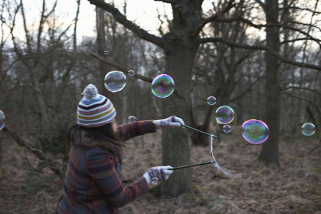 泡泡森林摄影照片_森林里的女人用泡泡魔杖做泡泡