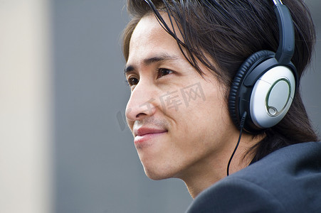 中年商人戴着耳机听音乐的特写