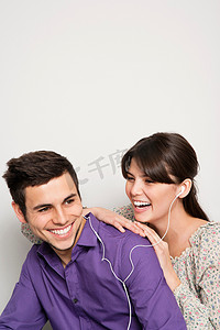 微笑的情侣听着耳机