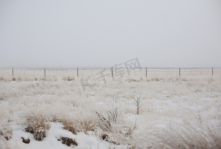 冬栅栏摄影照片_雪中的田野和栅栏