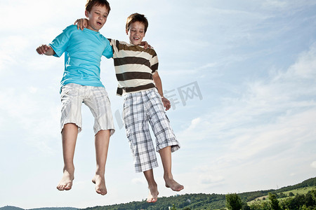 两个男孩在蹦床上跳