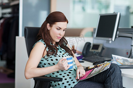 女人端着咖啡看杂志