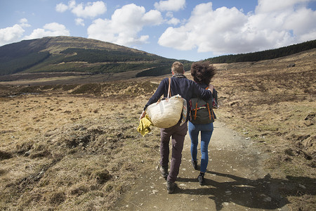 苏格兰赫布里底斯斯凯岛一对夫妇在山上的小路上徒步旅行仙女池