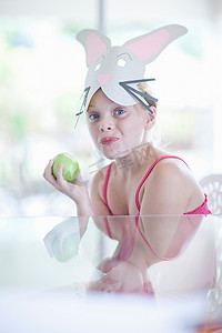 穿着兔子服装的女孩吃苹果