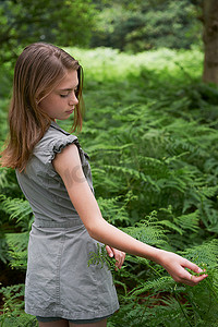 春风十里美丽如你摄影照片_十几岁的女孩在森林里摸蕨菜