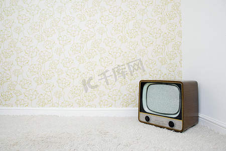 房间角落配有带图案墙纸的复古电视