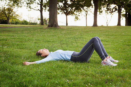 一名女子躺在公园的草地上