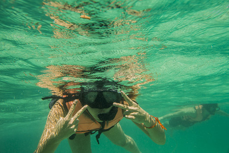 游戏浮岛摄影照片_年轻的男女浮潜水下景观泰国南原岛