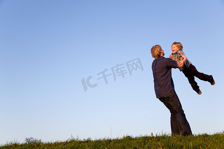 网络爱情摄影照片_父亲怀里抱着一个旋转的男孩