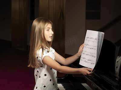 为钢琴选择乐谱的女孩
