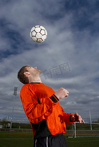 足球运动员将球顶向自己