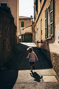 第几摄影照片_意大利伦巴第路易诺男孩在狭窄的街道上奔跑的后景