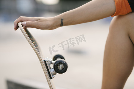 女子滑板运动员手持滑板的截图