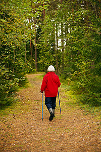 年长的女人在森林里徒步旅行
